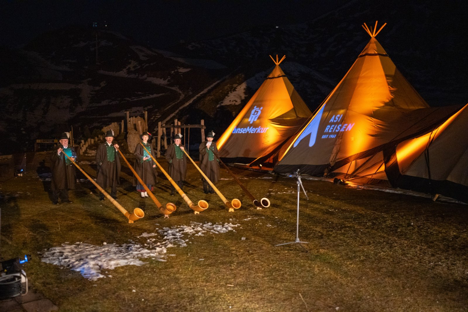 Alphornbläser vor beleuchteten Tipi-Zelten beim Hüttenabend der AER Jahrestagung auf der Seegrube